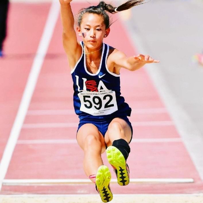 Annie Carey competing in the long jump