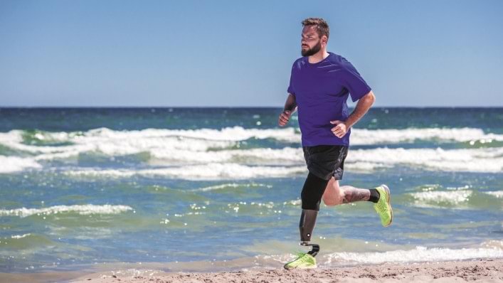 man running alongside beach with Challenger foot