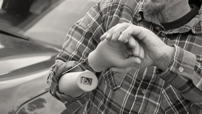 man wearing grasping hook working on small machine